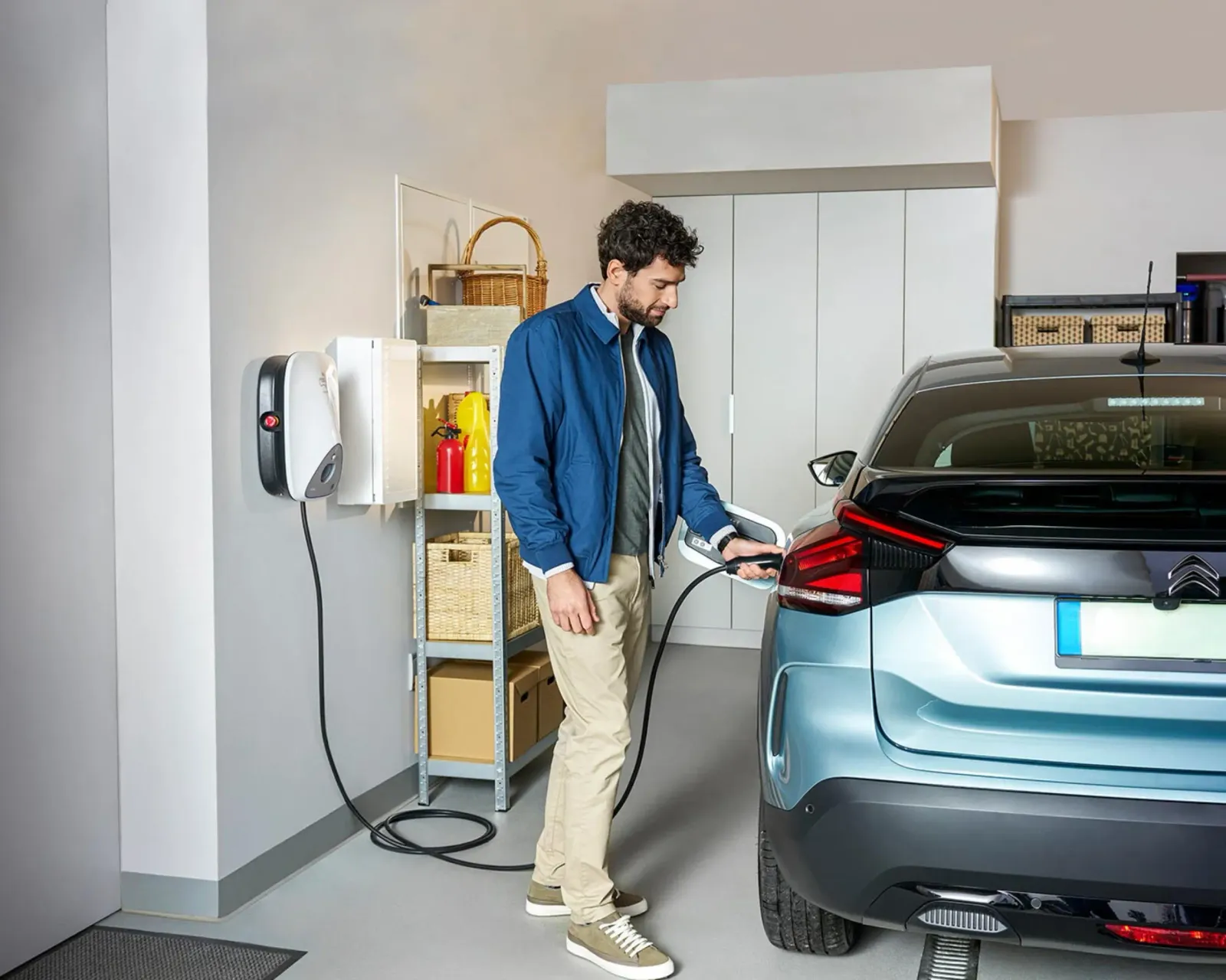Person lädt ihr E-Auto in der Garage mit einer Heizma Wallbox