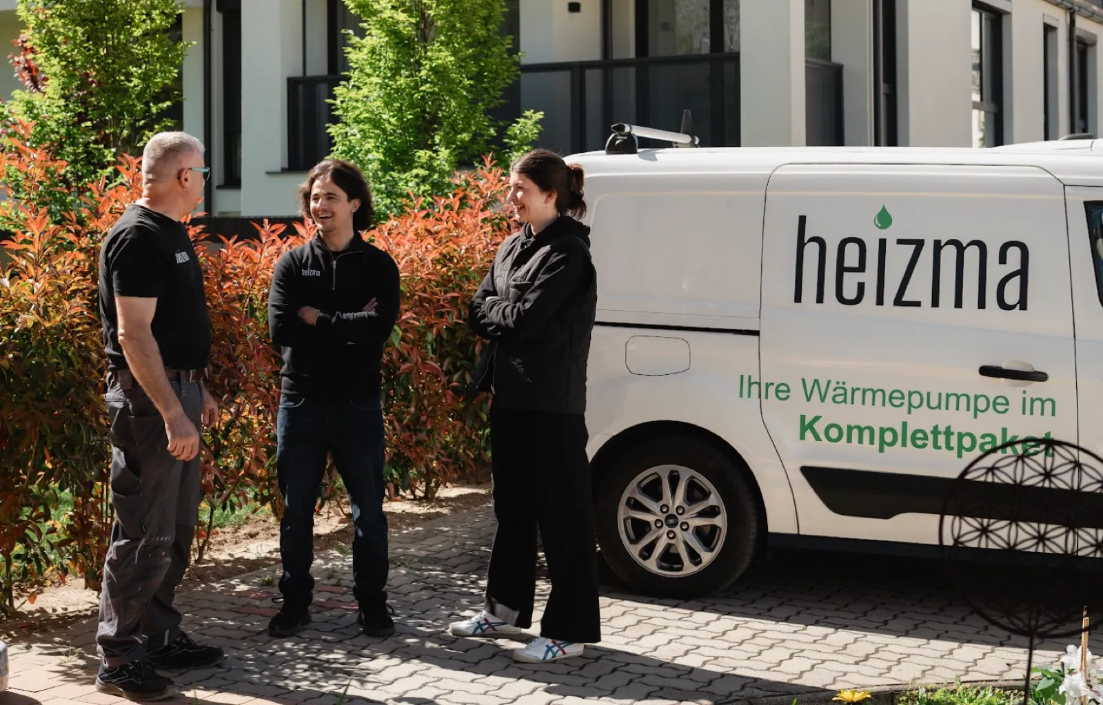 Heizma-Team im Gespräch vor dem Firmenbus